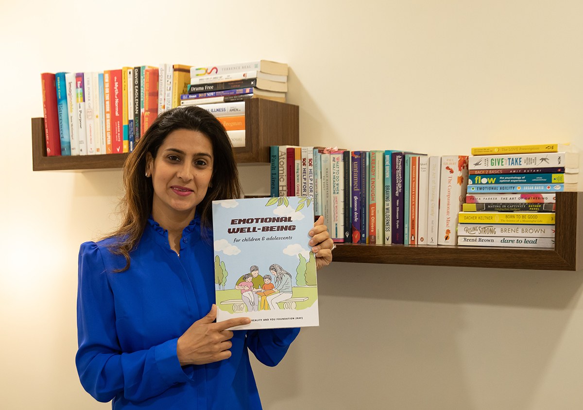 Shrradha Sidwani posing with her book Emotional Well-Being